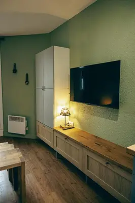 a large entertainment center with a large flat screen tv on a wall at Le Perchoir d'Edmond in Chamonix-Mont-Blanc