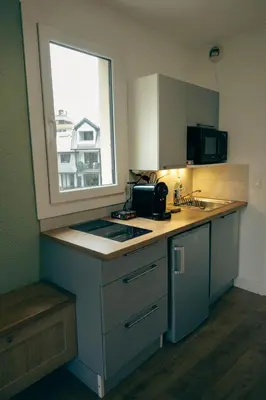 a kitchen with a counter top with a window at Le Perchoir d'Edmond in Chamonix-Mont-Blanc
