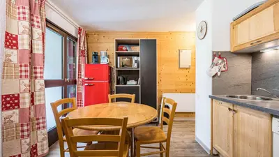 a kitchen with a table and chairs and a refrigerator at Grande Neige N 10 - 2P4 in Morillon