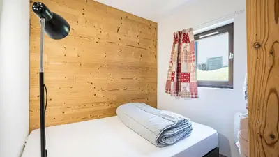 a room with a bed with a lamp and a wooden wall at Grande Neige N 10 - 2P4 in Morillon