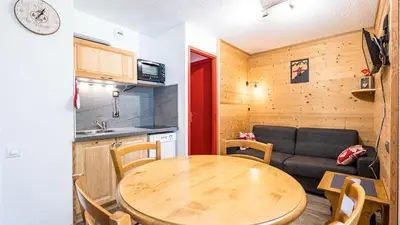 a kitchen and a table in a small room with a couch at Grande Neige N 10 - 2P4 in Morillon