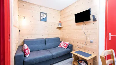 a living room with a couch and a flat screen tv at Grande Neige N 10 - 2P4 in Morillon