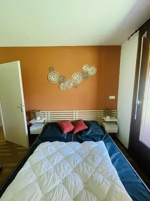 a bedroom with a bed with two red pillows on it at Les 3 balcons du Mont Joly in Les Contamines-Montjoie