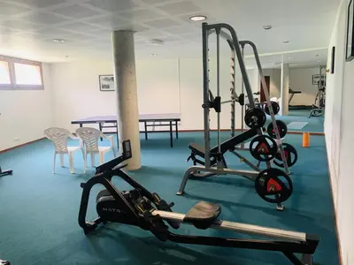 a gym with two tread machines and a table at Les 3 balcons du Mont Joly in Les Contamines-Montjoie