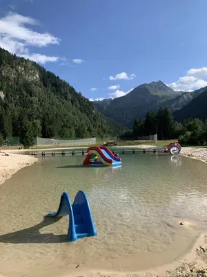 a pool of water with slides in the sand at Les 3 balcons du Mont Joly in Les Contamines-Montjoie