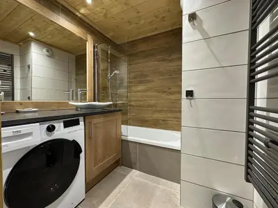 a bathroom with a washing machine and a bath tub at Joli appartement 2 chambres Belle Vue, Les Houches in Les Houches
