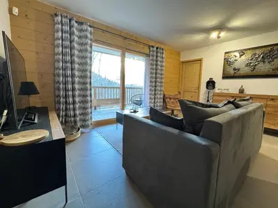 a living room with a couch and a television at Joli appartement 2 chambres Belle Vue, Les Houches in Les Houches