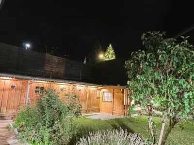 a wooden building with a fence at night at Megève centre in Megève