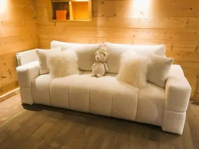 a teddy bear sitting on top of a white couch at Megève centre in Megève