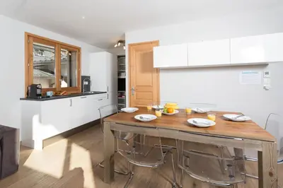a kitchen with a wooden table with plates on it at Sauberands 18 apartment - Chamonix All Year in Chamonix-Mont-Blanc