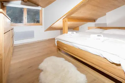 a bedroom with a large bed and a white rug at Sauberands 18 apartment - Chamonix All Year in Chamonix-Mont-Blanc