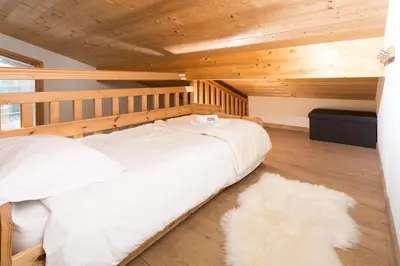 a bedroom with a white bed with a wooden ceiling at Sauberands 18 apartment - Chamonix All Year in Chamonix-Mont-Blanc