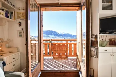a room with a balcony with a view of the mountains at Étoile Front de Neige in Demi-Quartier