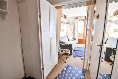 a hallway with a mirror and a living room at Étoile Front de Neige in Demi-Quartier