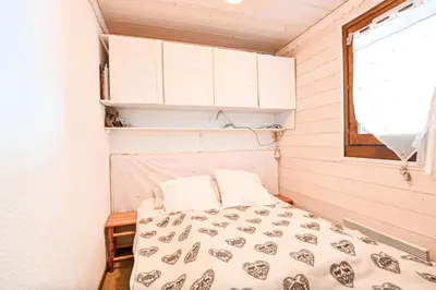 a small bedroom with a bed and a window at Étoile Front de Neige in Demi-Quartier