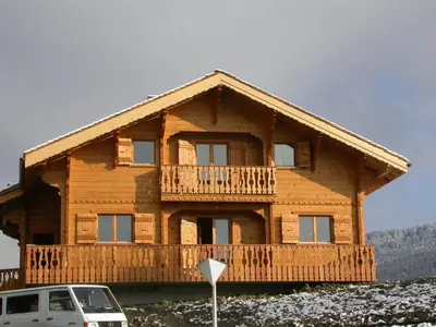 a log house with a balcony and a car parked in front at Chalet typique 5 chambres pour 10 personnes avec Wi-Fi et terrasse - FR-1-572-303 in Arâches-la-Frasse