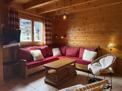 a living room with a red couch and a tv at Chalet typique 5 chambres pour 10 personnes avec Wi-Fi et terrasse - FR-1-572-303 in Arâches-la-Frasse