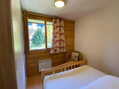 a bedroom with a bed and a window at Appartement 4-6 personnes centre Les Contamines Montjoie in Les Contamines-Montjoie