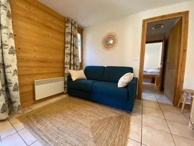 a living room with a blue couch in a room at Appartement 4-6 personnes centre Les Contamines Montjoie in Les Contamines-Montjoie