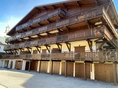 a large wooden building with wooden balconies on it at Appartement 4-6 personnes centre Les Contamines Montjoie in Les Contamines-Montjoie