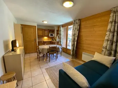 a living room with a blue couch and a table at Appartement 4-6 personnes centre Les Contamines Montjoie in Les Contamines-Montjoie