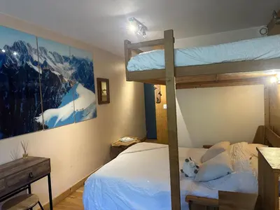 a bedroom with two bunk beds and a desk at Nouveau Refuge de l aiguille in Chamonix-Mont-Blanc