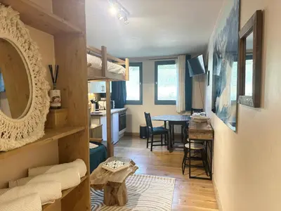 a living room with a bunk bed and a dining room at Nouveau Refuge de l aiguille in Chamonix-Mont-Blanc