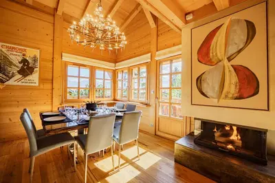 a dining room with a table and a fireplace at Chalet des Sommets in Combloux