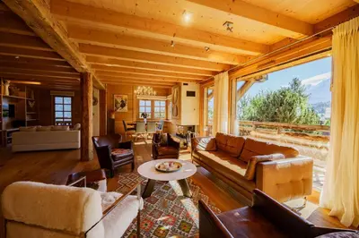 a living room filled with furniture and a large window at Chalet des Sommets in Combloux