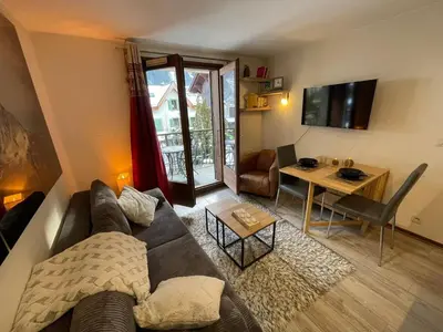 a living room with a couch and a table at Downtown Chamonix Studio & Stunning Mountain View in Chamonix-Mont-Blanc