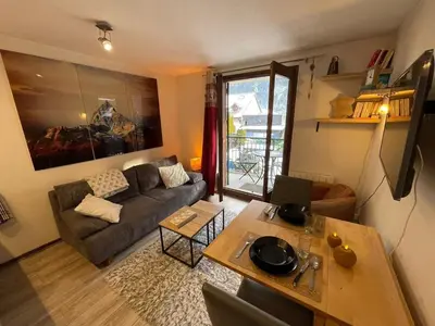 a living room with a couch and a table at Downtown Chamonix Studio & Stunning Mountain View in Chamonix-Mont-Blanc