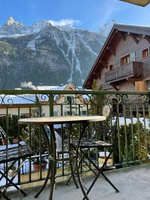 a table and chairs on a balcony with a mountain at Downtown Chamonix Studio & Stunning Mountain View in Chamonix-Mont-Blanc