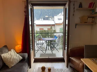 a living room with a door open to a balcony at Downtown Chamonix Studio & Stunning Mountain View in Chamonix-Mont-Blanc