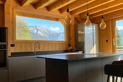 a kitchen with a large window with a mountain view at Chalet Le M - Adults only - Standing - Samoëns Grand-Massif in Samoëns