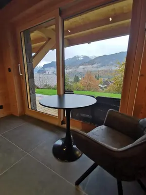 a table and a chair in a room with a window at Chalet Le M - Adults only - Standing - Samoëns Grand-Massif in Samoëns