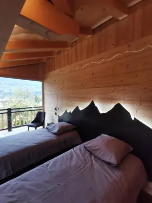 a bedroom with a large bed with a wooden wall at Chalet Le M - Adults only - Standing - Samoëns Grand-Massif in Samoëns