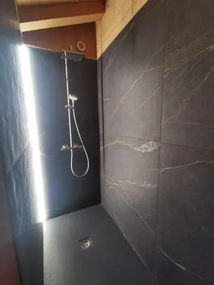 a shower in a bathroom with a black wall at Chalet Le M - Adults only - Standing - Samoëns Grand-Massif in Samoëns