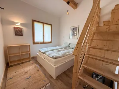 a bedroom with a bed and a wooden staircase at Apartment in Chamonix in Chamonix-Mont-Blanc