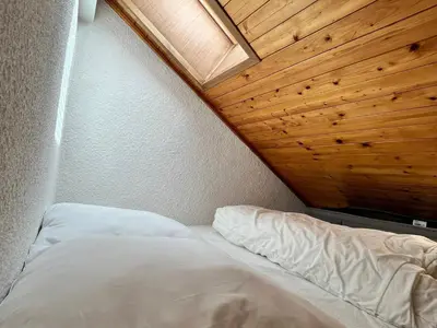 a bed in a room with a wooden ceiling at Studio cosy au centre de Samoëns, animaux acceptés - FR-1-624-183 in Samoëns