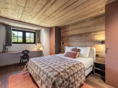 a bedroom with a bed and a wooden wall at Chalet calme à Megève - 4 chambres, proche centre, parking inclus - FR-1-569-201 in Megève