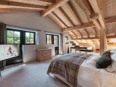 a bedroom with a large bed with a television in it at Chalet calme à Megève - 4 chambres, proche centre, parking inclus - FR-1-569-201 in Megève