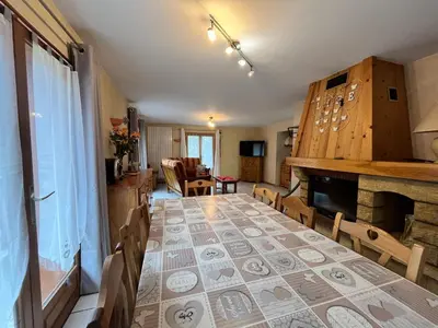 a dining room with a table and a fireplace at Chalet chaleureux au pied des pistes avec animaux acceptés - FR-1-624-184 in Samoëns