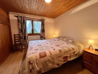 a bedroom with a bed and a wooden ceiling at Chalet chaleureux au pied des pistes avec animaux acceptés - FR-1-624-184 in Samoëns