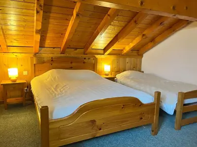 two beds in a room with wooden ceilings at Chalet chaleureux au pied des pistes avec animaux acceptés - FR-1-624-184 in Samoëns