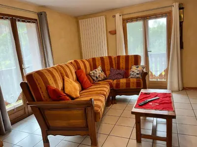 a living room with a couch and a table at Chalet chaleureux au pied des pistes avec animaux acceptés - FR-1-624-184 in Samoëns