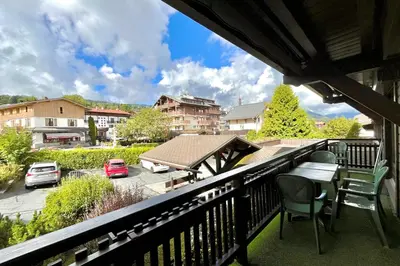a balcony with a table and chairs overlooking a parking lot at Cœur Combloran in Combloux
