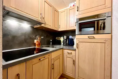 a kitchen with wooden cabinets and a sink at Cœur Combloran in Combloux