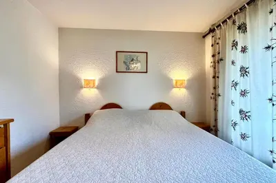 a bedroom with a white bed and two chairs at Cœur Combloran in Combloux