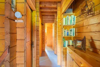 a hallway in a wooden house with bookshelves at L'Écrin des Anges Chalet cosy, Ski et Vue in Combloux