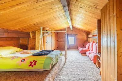 a bedroom with a bed in a wooden cabin at L'Écrin des Anges Chalet cosy, Ski et Vue in Combloux